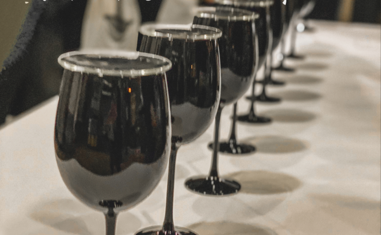 8 wine glasses filled with red wine