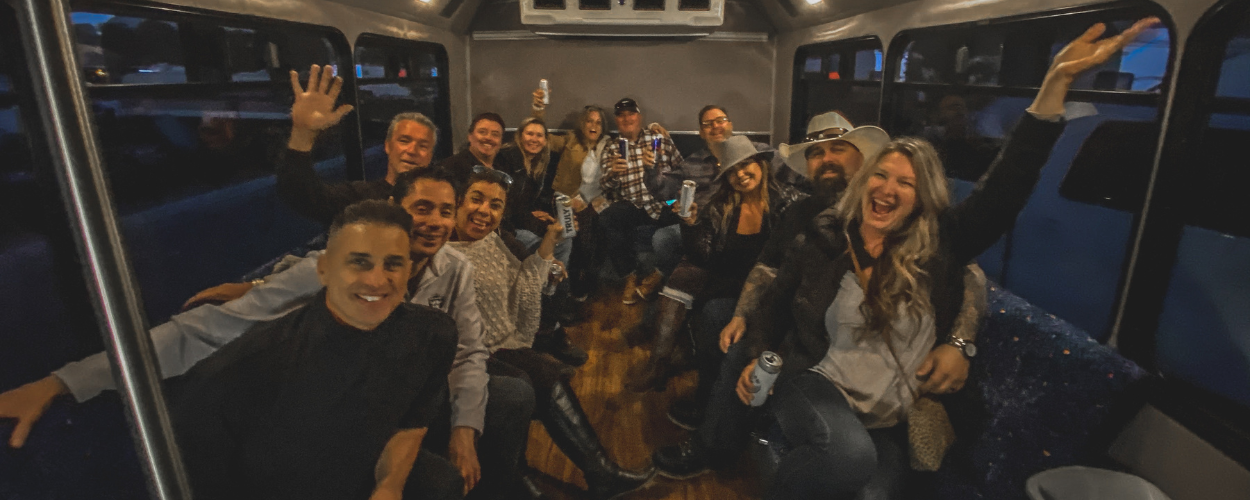 A LARGE GROUP HAVING FUN ON A WINE TOUR BUS