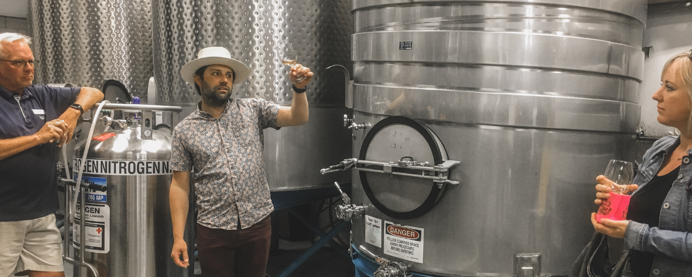 A MAN VISUALLY TASTING WINE IN A PASO WINERY