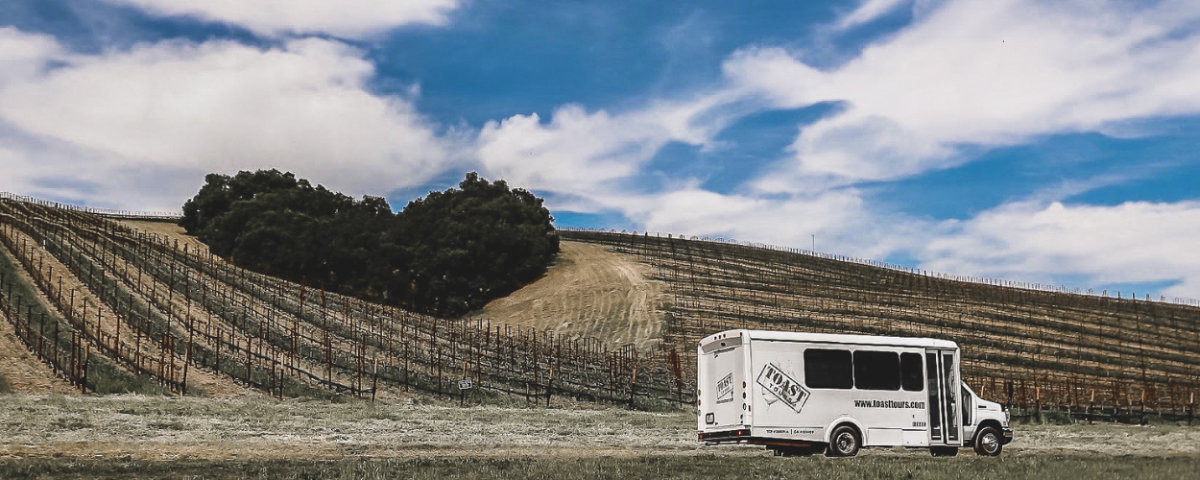 TOAST TOURS VAN DRIVING IN A PASO ROBLES WINERY IN FRONT OF HEART HILL