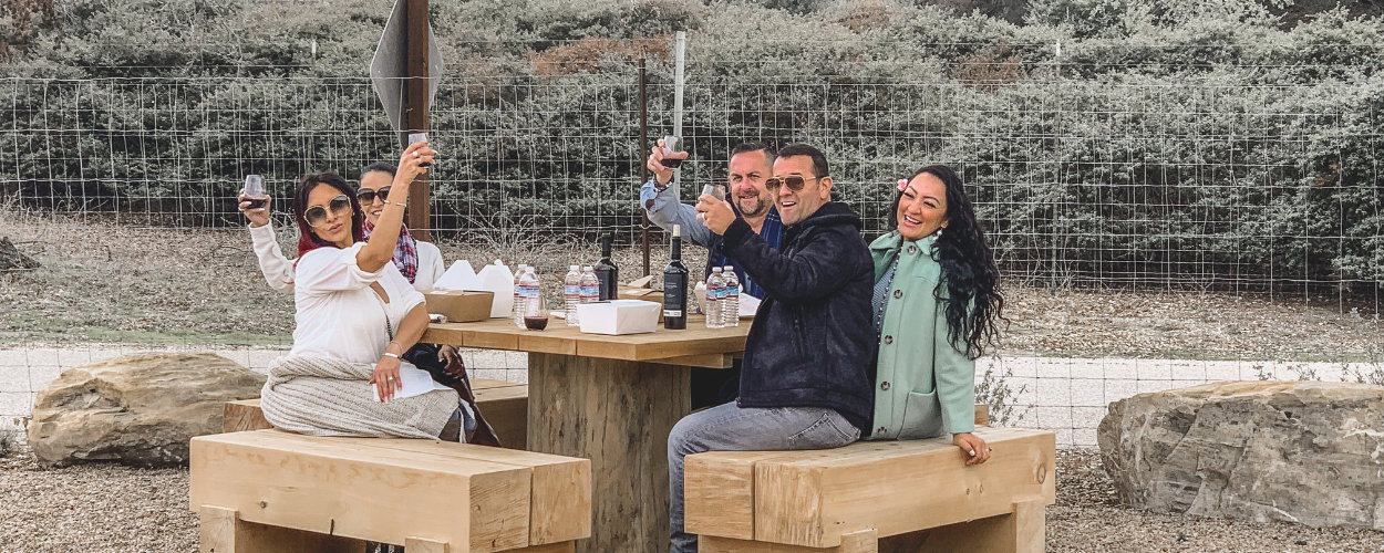 a group of friends having lunch and wine on their day of wine tasting in paso