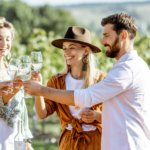 a group of friends that went wine tasting together cheersing in a vineyard