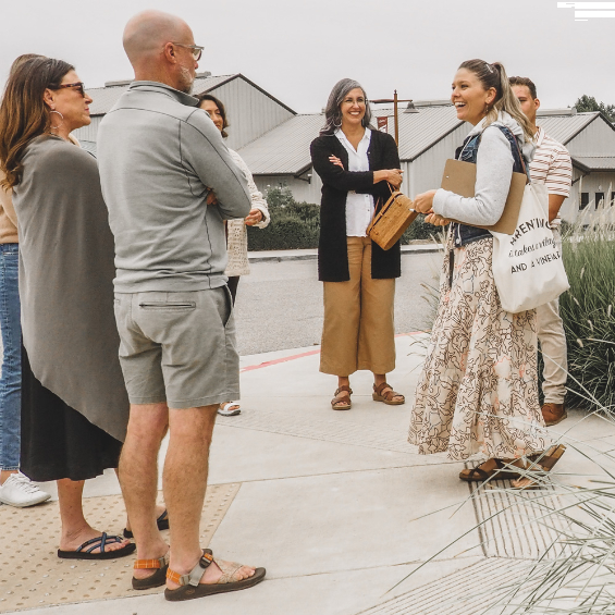 walking tour group made up of 6 people and the tour guide standing in front of the tin city sign