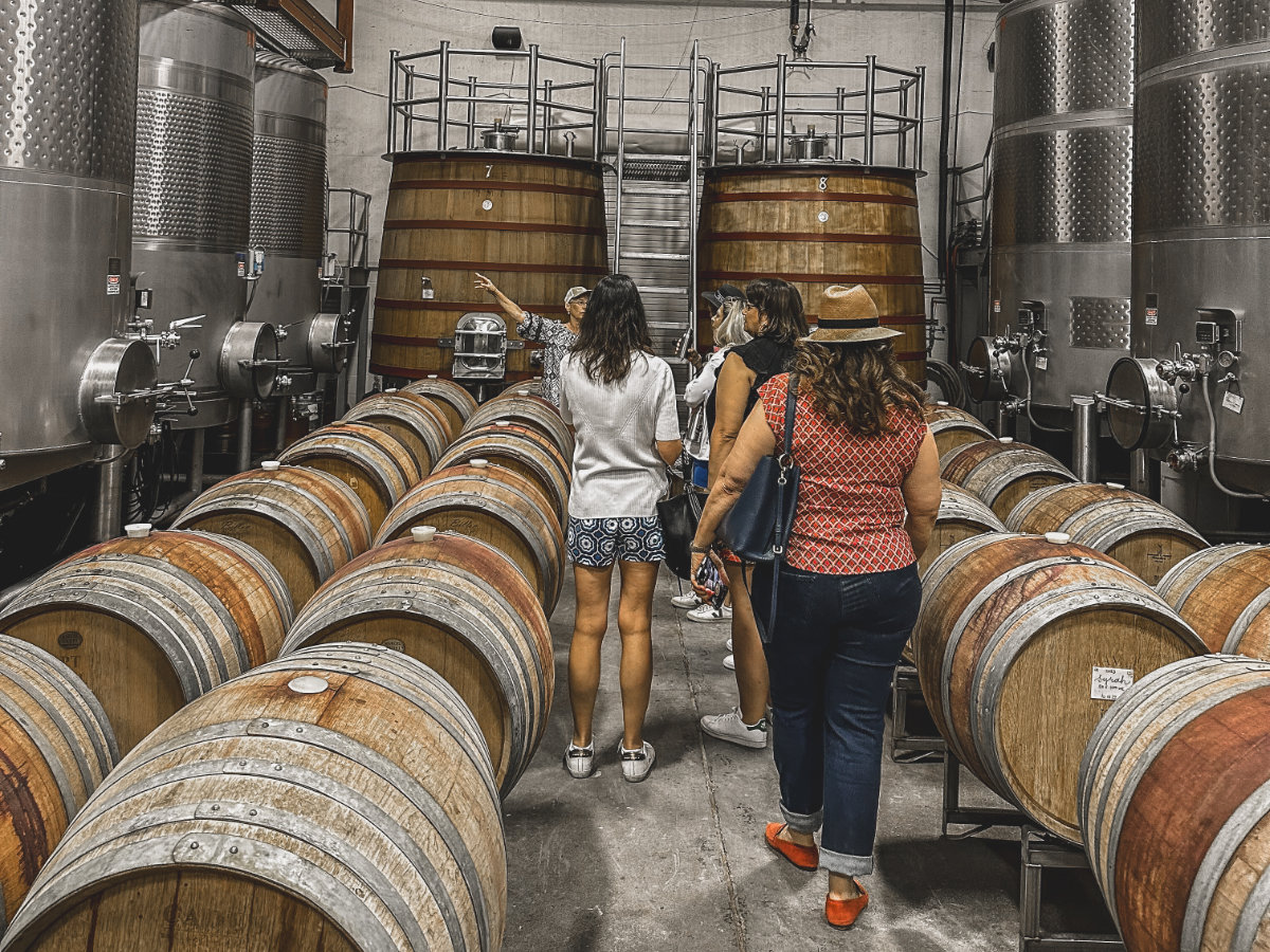 group of woman on a tour in a barrel room