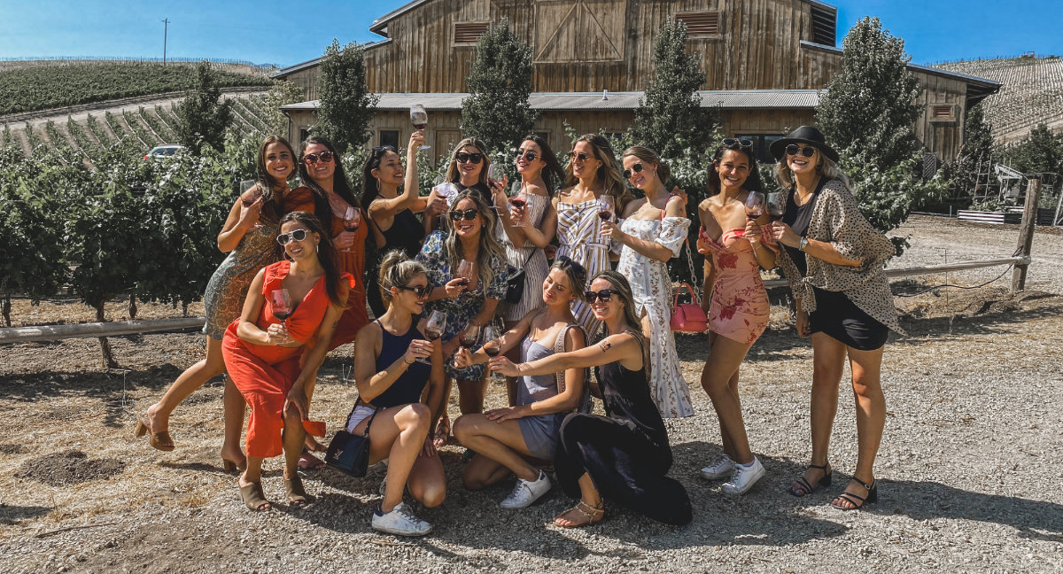 Group of girls posing in front of a barn in wine country