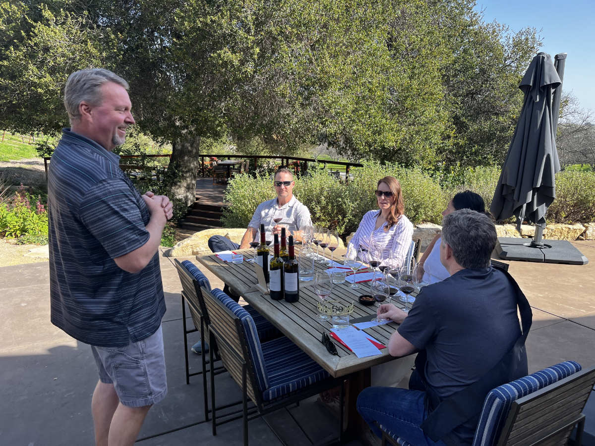 host talking to people tasting wine